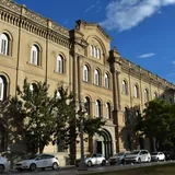 Fachada histórica del Colegio de la Inmaculada Concepción en la Manzana Jesuítica de Santa Fe, un edificio de tres pisos con ventanas en arco de medio punto frente a una calle con autos estacionados.