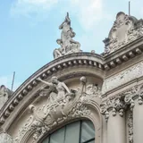 Detalle arquitectónico superior del Teatro Municipal 1° de Mayo en Santa Fe, mostrando molduras clásicas y un conjunto de esculturas alegóricas sobre piedra.