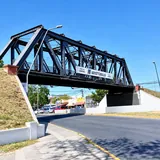 El icónico Puente Negro sobre la avenida Aristóbulo del Valle en Santa Fe, una estructura ferroviaria metálica de color oscuro bajo un cielo azul despejado.